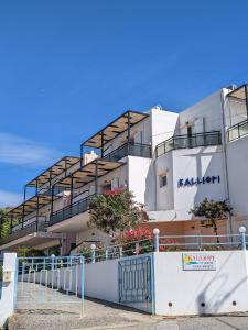 un edificio blanco con balcones en un lateral en Kalliopi Studios - Apartments, en Kato Daratso