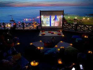 a large screen with a movie on a balcony at night at LİFOZ Holiday resort in Trabzon