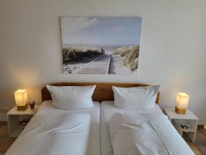 - 2 lits dans une chambre avec une photo sur le mur dans l'établissement Ferienwohnung 58 im Haus Villa Anna, à Sankt Peter-Ording