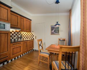 a kitchen with wooden cabinets and a wooden table at MONDI Hotel Bellevue Gastein in Bad Gastein +55 photos