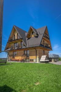 a large wooden house with a gambrel roof at Widokowe Domki Gawlaki in Zakopane