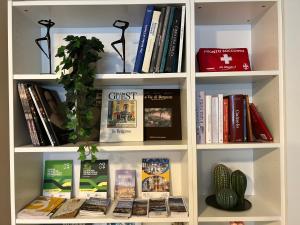 a book shelf filled with books and a plant at Sonila's Home in Bergamo