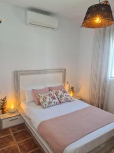a bedroom with a white bed with two pillows on it at Villa Encanto in Chiclana de la Frontera