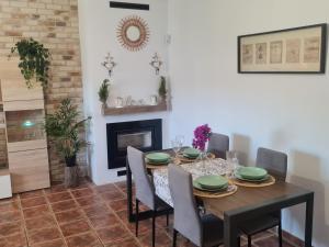 een eetkamer met een tafel en stoelen en een open haard bij Villa Encanto in Chiclana de la Frontera