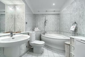 a white bathroom with a sink and a toilet and a tub at Your Holidays Chrobry in Międzyzdroje +31 photos