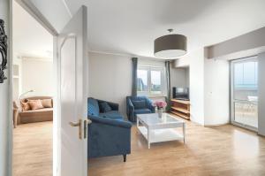 a living room with a blue couch and a table at Your Holidays Chrobry in Międzyzdroje