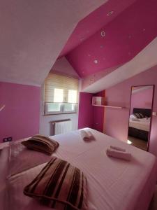 1 dormitorio con 1 cama grande y techo púrpura en Guest house Klara, en Solin