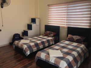 a room with two beds and a window at Safi Kitchen Hostel in Aş Şāfī