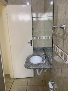 baño con lavabo y puerta blanca en Pissin Plaza Hotel, en Goiânia