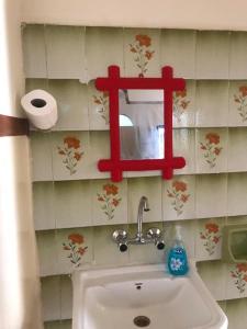 a bathroom with a sink and a red cross on the wall at Safi Kitchen Hostel in Aş Şāfī