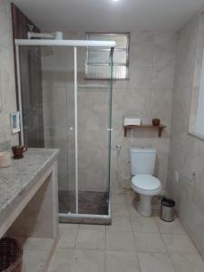 uma casa de banho com um WC e uma cabina de duche em vidro. em B&B Caminho da Floresta em Miguel Pereira