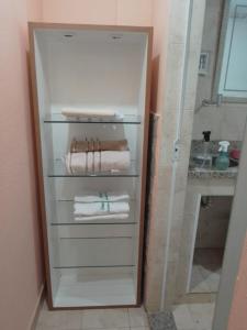 a white refrigerator with towels in a bathroom at B&B Caminho da Floresta in Miguel Pereira