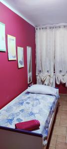um quarto com uma cama com uma parede vermelha em Casa Agnese em Marina di Camerota