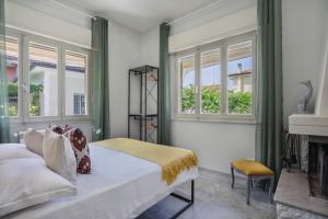 1 dormitorio con cama, ventanas y chimenea en I Levrieri b&b, en Torre del Lago Puccini