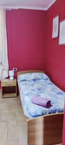 um quarto com uma cama e uma parede rosa em Casa Agnese em Marina di Camerota