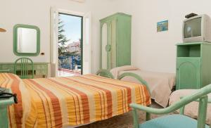 a bedroom with two beds and a tv and a window at Hotel Del Postiglione in Ischia