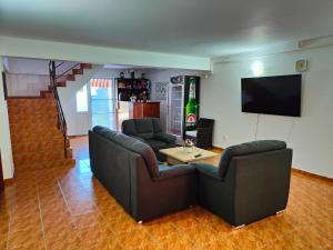 Sala de estar con 2 sofás, mesa y TV en Vila Olimpica, en Costinesti