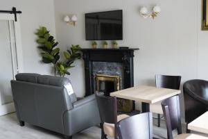 een eetkamer met een tafel en stoelen en een televisie bij Slieve Bloom Manor Hostel in Killarney