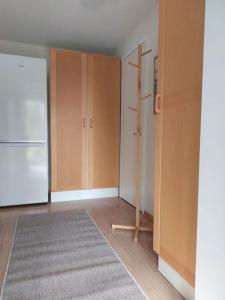a kitchen with wooden cabinets and a white refrigerator at Lönngården in Kristiinankaupunki