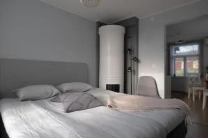 een slaapkamer met een groot bed met witte lakens en kussens bij Lönngården in Kristiinankaupunki