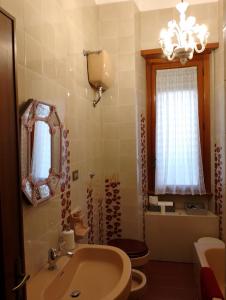 a bathroom with a sink and a toilet and a mirror at a un passo dal mare in Lido di Ostia