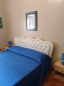 a bedroom with a bed with a blue bedspread at a un passo dal mare in Lido di Ostia