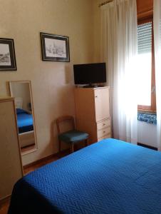 a bedroom with a bed and a tv and a mirror at a un passo dal mare in Lido di Ostia