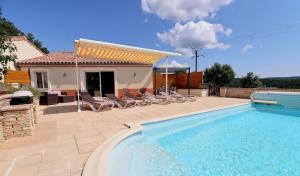a swimming pool with chairs and a house at Gîte myosotis Piscine Privée 4 Chambres in Lagorce