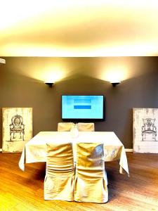 a room with a table and a tv on the wall at Lake Apartment 3 in Bissone