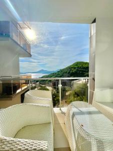 a balcony with two chairs and a view of the ocean at Sea view Apartments Panorama Przno in Sveti Stefan