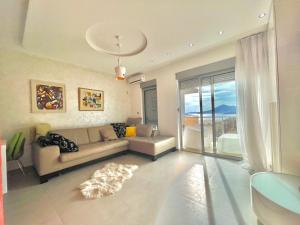 a living room with a couch and a large window at Sea view Apartments Panorama Przno in Sveti Stefan