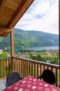 a table on a balcony with a view of a lake at Dolomites Chalet Wolf in Molveno