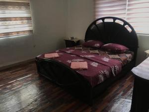 a bedroom with a black bed with red pillows at Safi Kitchen Hostel in Aş Şāfī