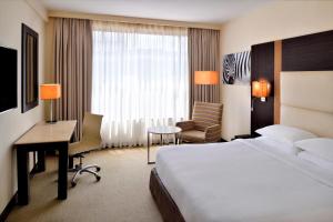 a hotel room with a bed and a desk and chair at Four Points By Sheraton Nairobi Hurlingham in Nairobi