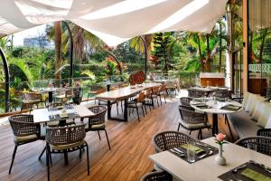 a restaurant with tables and chairs and trees at Four Points By Sheraton Nairobi Hurlingham in Nairobi