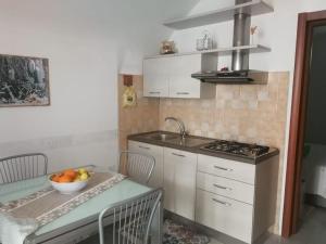 a kitchen with a bowl of fruit on a table at La casetta di Ramona in Noto