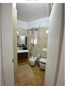 La salle de bains est pourvue d'un lavabo, de toilettes et d'une baignoire. dans l'établissement Lungo mare holiday apartment for family, à Vlorë