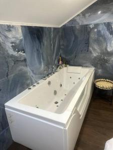 Villa Jacqueline في coutances: حمام مع حوض استحمام أبيض في الغرفة