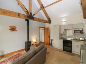 a living room with a couch and a stove at Dubh Sgeir Annex in Berwick-Upon-Tweed