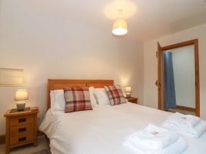 um quarto com uma cama branca e toalhas em Dubh Sgeir Annex em Berwick-Upon-Tweed