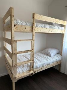- un lit superposé en bois avec une échelle et un couvre-lit dans l'établissement Villa Jacqueline, à coutances