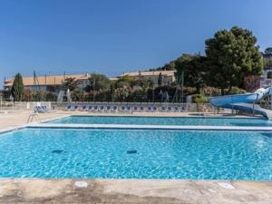 une grande piscine avec de l'eau bleue et des chaises dans l'établissement appartement dans résidence avec piscine, à La Londe-les-Maures 6 autres photos