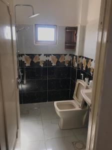 a bathroom with a toilet and a sink and a window at Safi Kitchen Hostel in Aş Şāfī