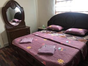 a bedroom with a bed with a mirror and pillows at Safi Kitchen Hostel in Aş Şāfī