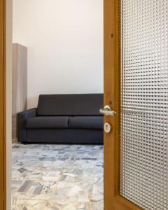 une porte menant à un salon avec un canapé dans l'établissement Nopal casa vacanze, à San Vito dei Normanni