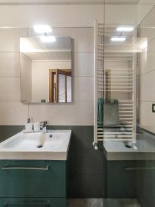 La salle de bains est pourvue d'un lavabo blanc et d'un miroir. dans l'établissement Nopal casa vacanze, à San Vito dei Normanni