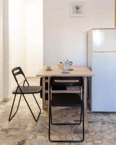 a table and chairs in a kitchen with a refrigerator at Nopal casa vacanze in San Vito dei Normanni