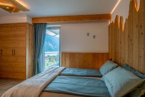 a bedroom with a large bed with a large window at Dolomites Chalet Wolf in Molveno