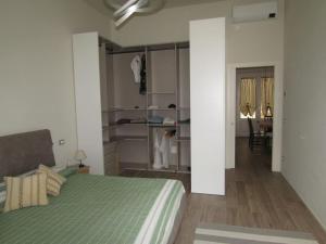 a bedroom with a green bed and a room with a table at Appartamento in centro storico. in Camaiore