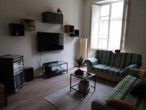 a living room with a couch and a tv at Appartamento in centro storico. in Camaiore